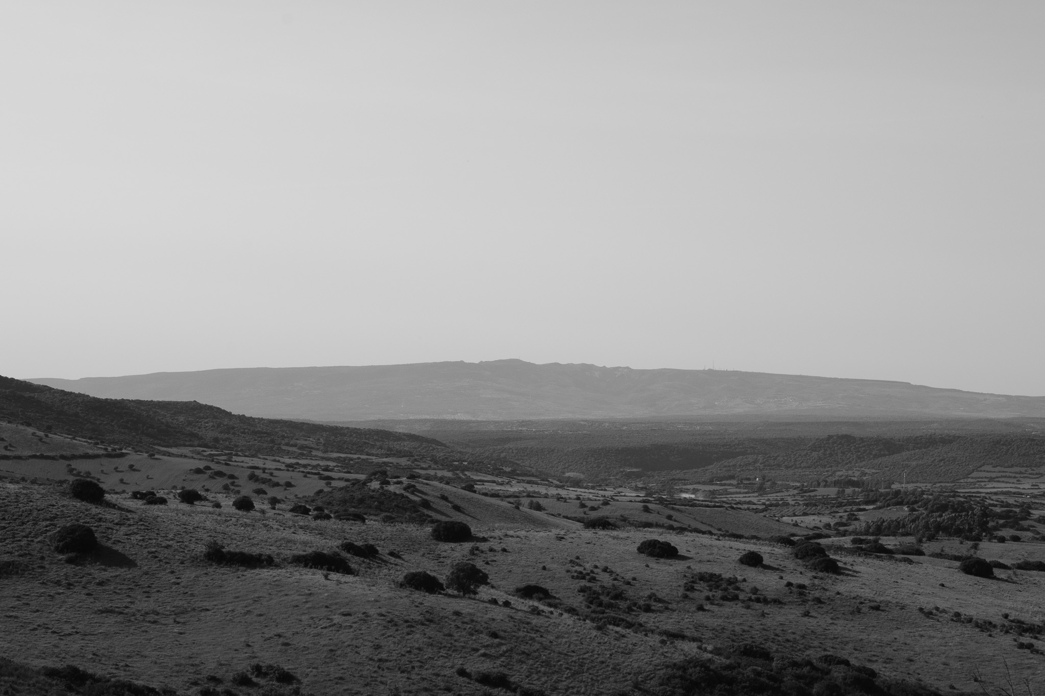 Black and white landscape with rolling hills and mountains